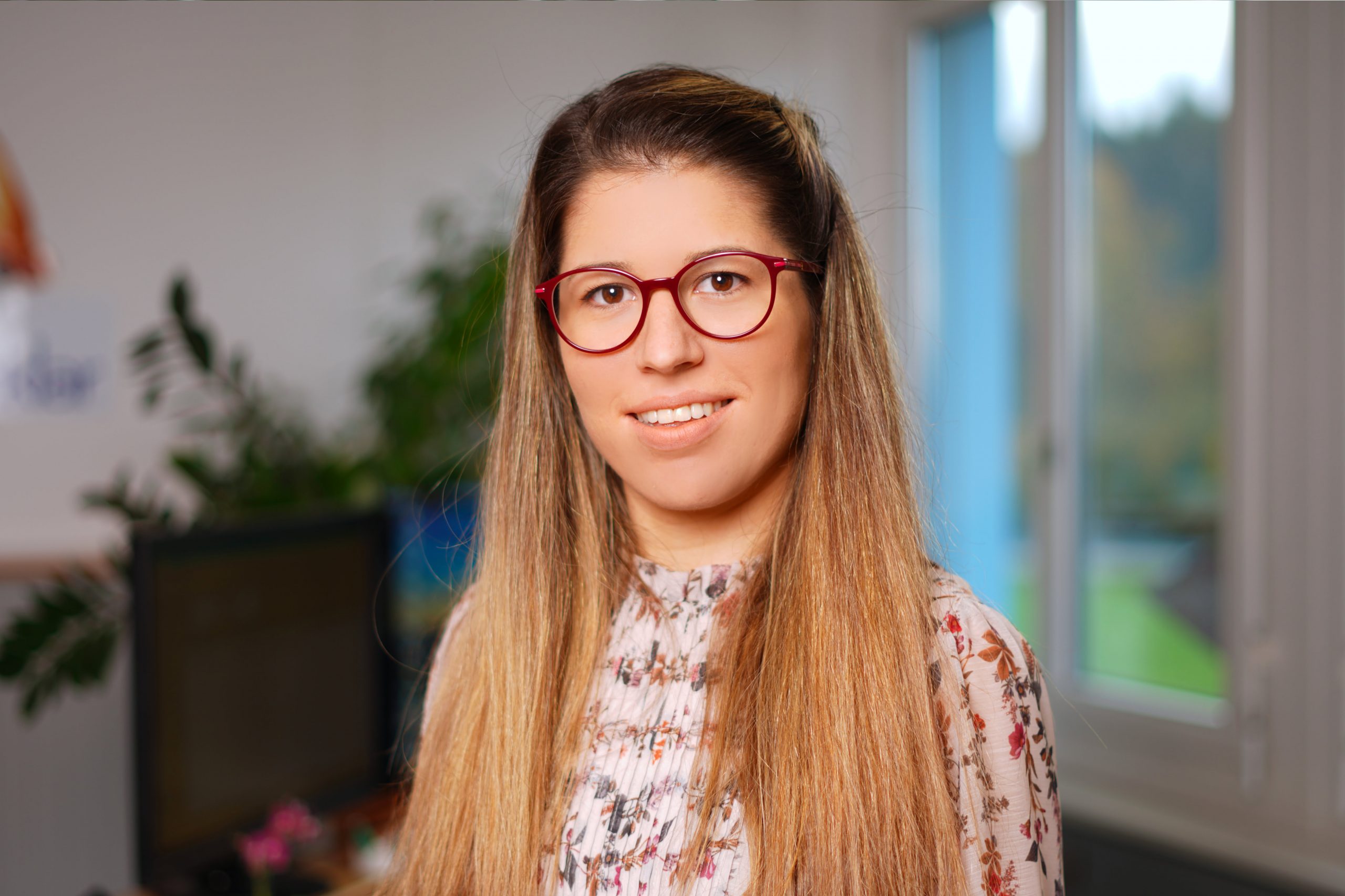A female Kristall Klar employee with long hair and glasses